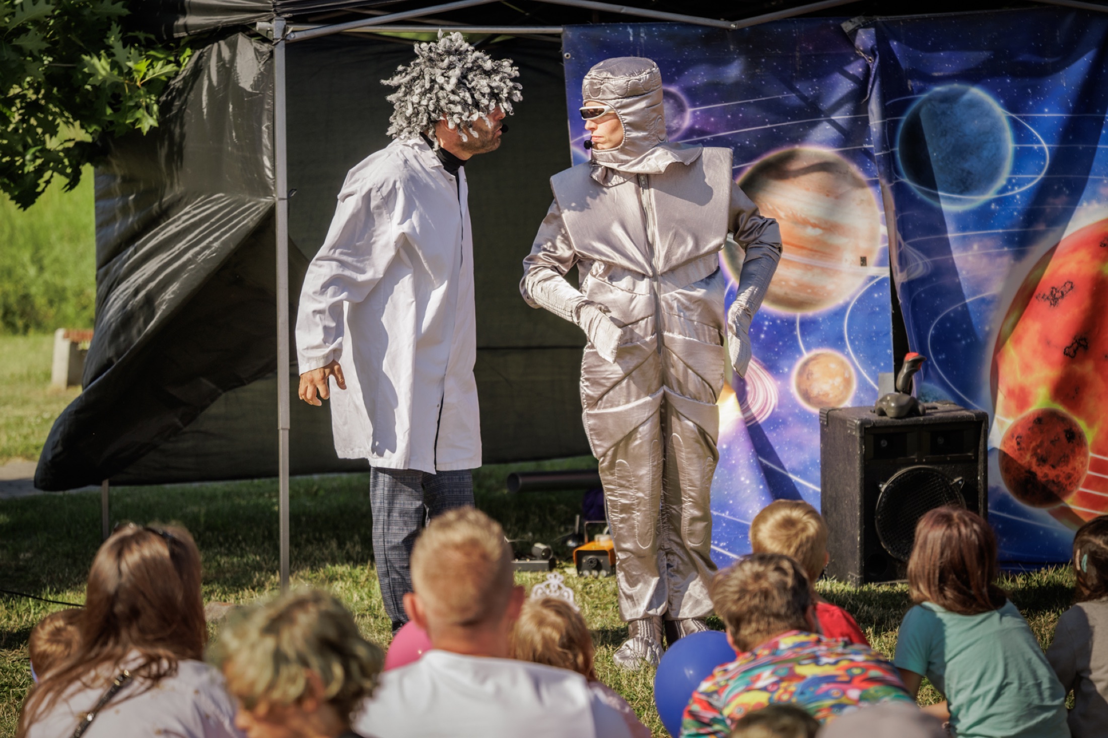 Rodziny oglądają spektakl podczas wydarzenia plenerowego